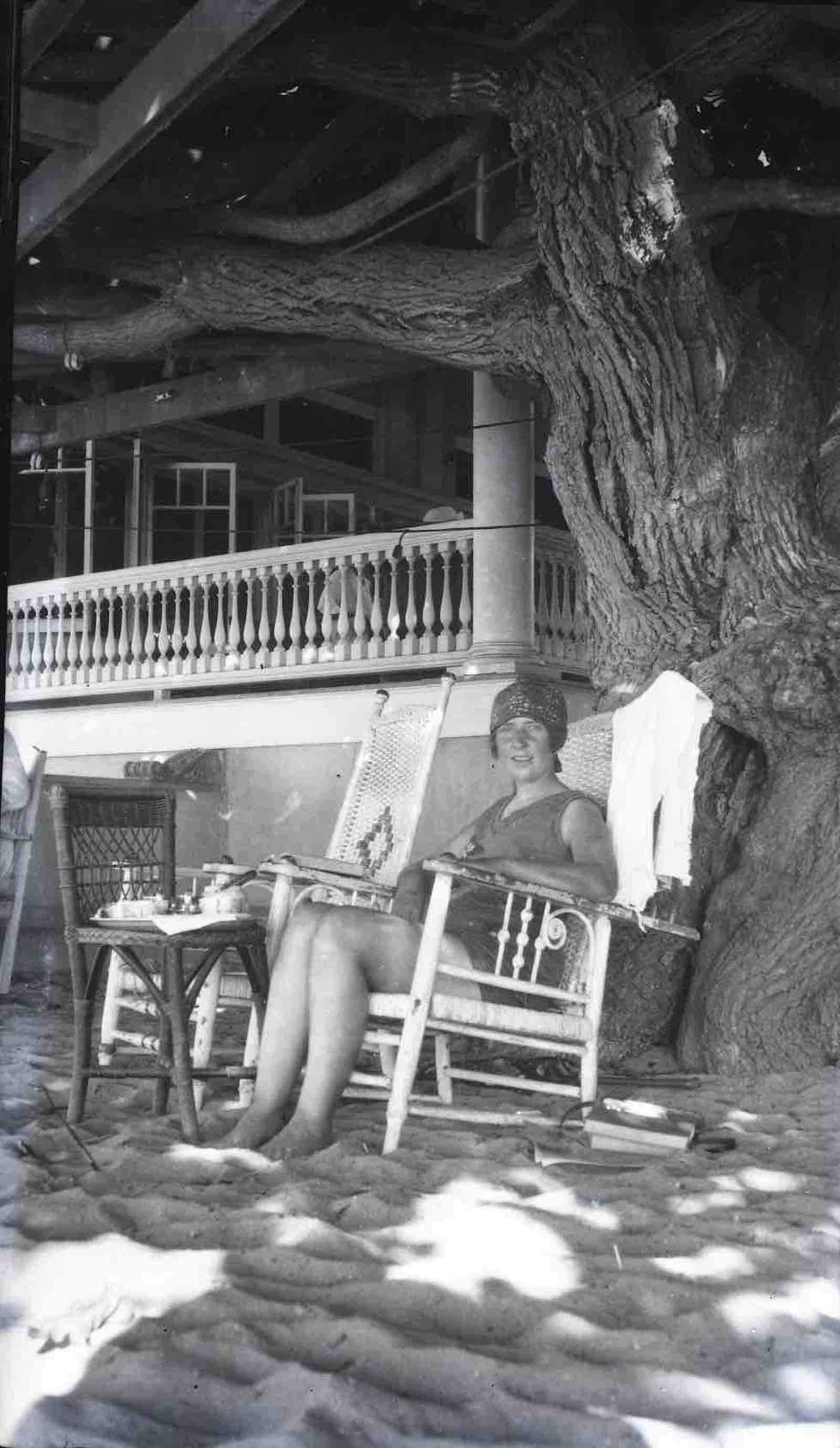 Agatha Christie under a tree on Honolulu beach after surfing, 1922.