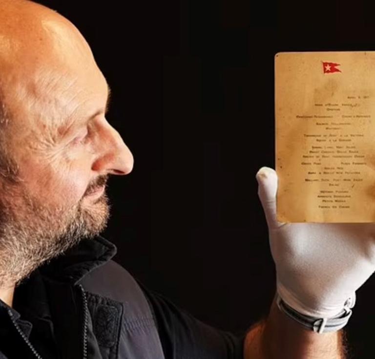 Auctioneer Andrew Aldridge holding the menu